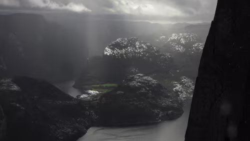 Preikestolen Die Sonne bricht durch die Wolken und die Felsen der Berge schimmern darin
