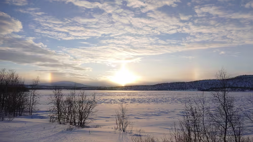 Koskullskulle – Tromsø Rechts und links sind weitere Lichtbrechungen (Nebensonnen) der Sonne (in der Mitte) zu sehen