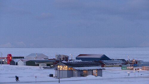 Longyearbyen Im Vordergrund wieder ein Feuerhaus und hinten dran Teile des Industriegebietes. Der Adventfjorden ist im Sichtbereich zugefroren