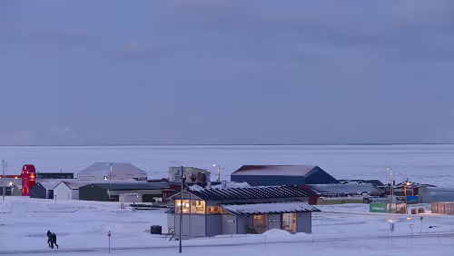 Longyearbyen Im Vordergrund wieder ein Feuerhaus und hinten dran Teile des Industriegebietes. Der Adventfjorden ist im Sichtbereich zugefroren