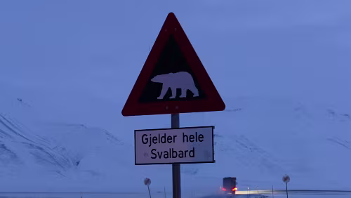 „Longyearbyen in a nutshell“ Tour „Gjelder hele Svalbard“ - „Gilt auf ganz Spitzbergen“. Das Schild steht am Straßenrand der Straße/Piste die von Longyearbyen in Richtung Osten führt, zur Gruve...