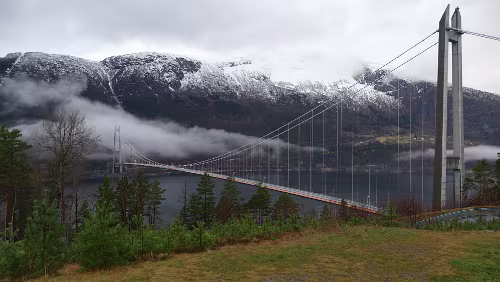 Vågsli - Bergen Die Hardangerbrua (deutsch Hardangerbrücke) ist eine Hängebrücke über den Eidfjord in Norwegen. Gesamtlänge: 1380 m; Höhe: 202 m; Lichte Höhe: 55 m