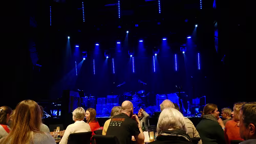 Tromsø – Longyearbyen Das einzige Konzert heute Abend, das „Vorspiel“. In der vordersten Reihe stehen Tische mit Stühlen, dahinter sind Stuhlreihen.