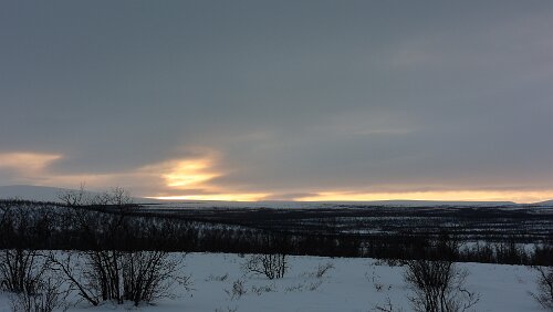 Vuollerim – Tromsø Die Sonne zeigt sich über dem Horizont.