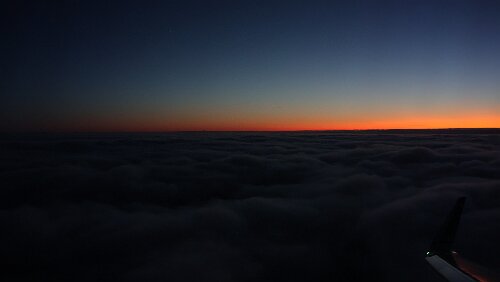 Tromsø – – – Longyearbyen Vorbereitung zu Landung, gleich geht es in die Wolkendecke rein. Blick nach Süden, letzte Sonnenstrahlen.