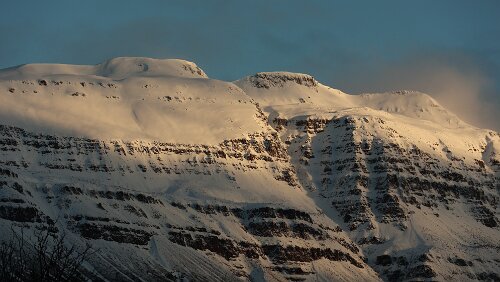 Seyðisfjörður Die verschneiten Berge um Seyðisfjörður werden von den ersten Sonnenstrahlen erwacht.