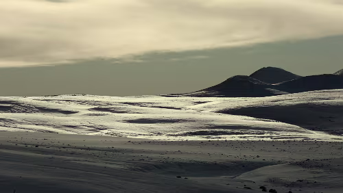 Seyðisfjörður – Mývatn Der Schnee wird in gelbes Licht getaucht.