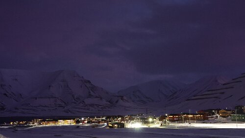 Rundgang in Longyearbyen Blick vom „Vei 300“ auf Longyearbyen. Man sieht den nicht zugefrorenen „Adventfjorden“. Die Berge hinten dann sind das „Hiorthfjellet“ und der „Dirigenten“....