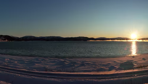 Bodø – Saltfjellet – Mosjøen Sonnenaufgang am „ Skjerstadfjorden “. Im Vordergrund die Eisenbahnlinie zwischen Fauske und Bodø. Panorama .